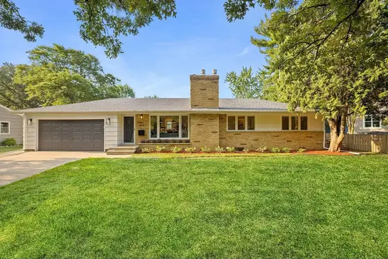 Mid-century ranch home with a freshly planted foundation garden bed and manicured front lawn